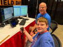 Youth Lounge volunteers Charlie Hibbs, KR4LXJ (front), and Todd Cline, N7KDT, operating the Get On the Air – GOTA – station from the 2026 Huntsville Hamfest.